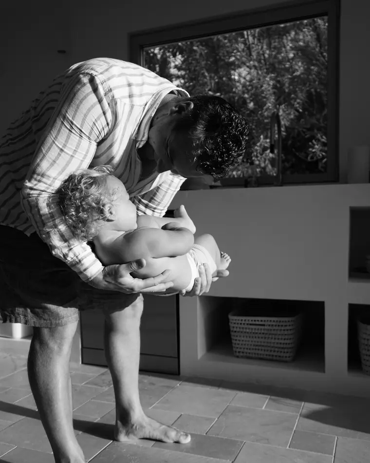 Family photographer in Paris: dad and baby, black and white